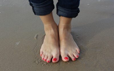 Naisen jalat hiekkarannalla.